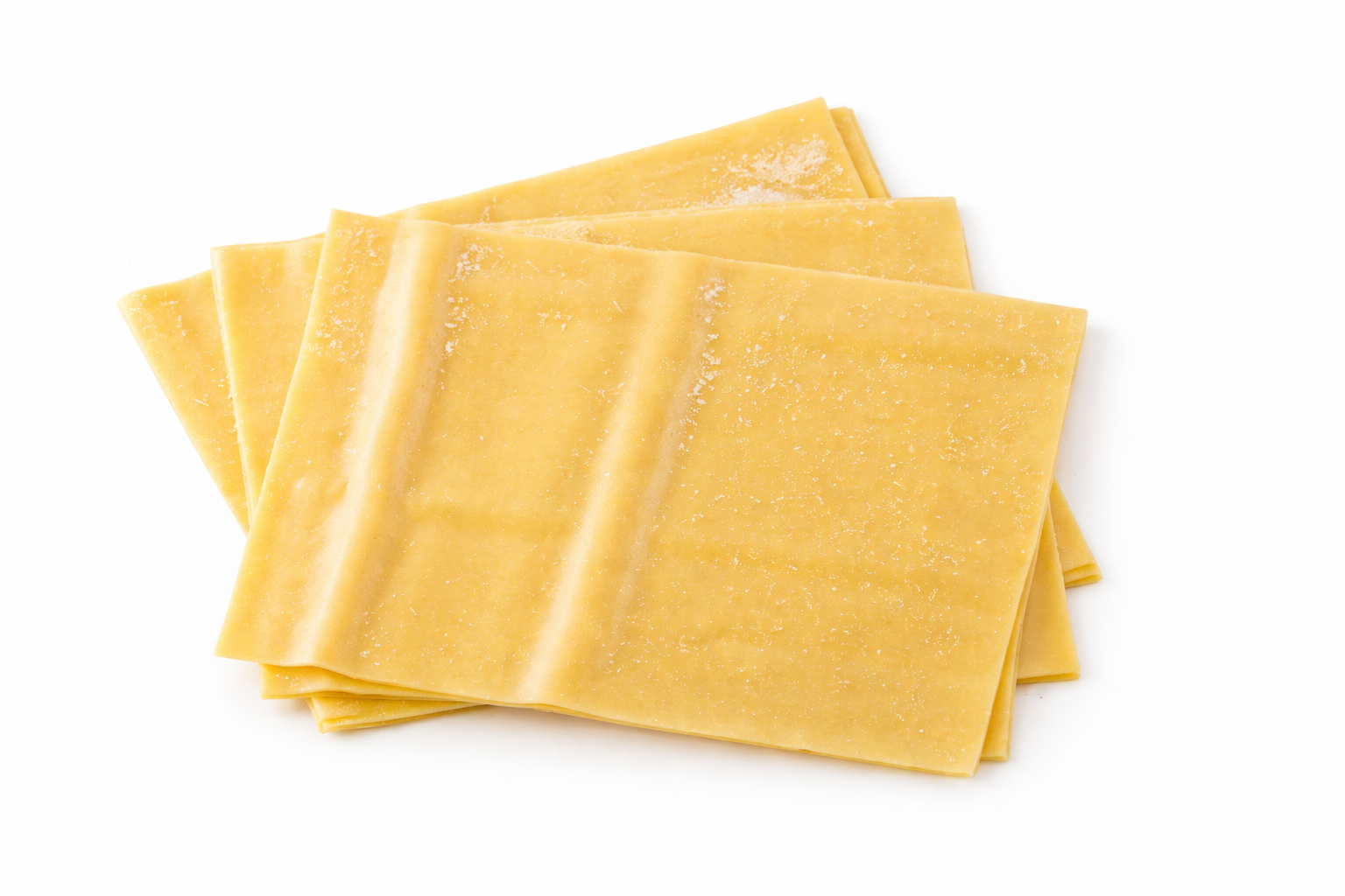 Feuilles de lasagne fraîches, fines et légèrement farinées, disposées en éventail sur fond blanc.